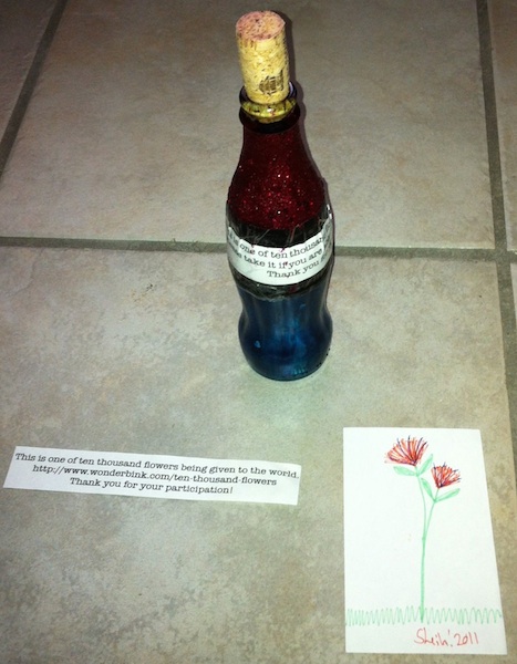A bottle, a note and a drawing of a flower