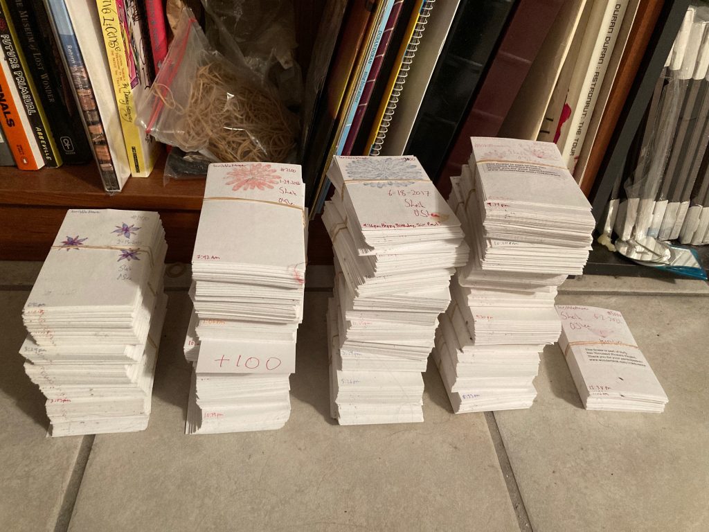 Large stacks of index cards with flowers drawn on them.
